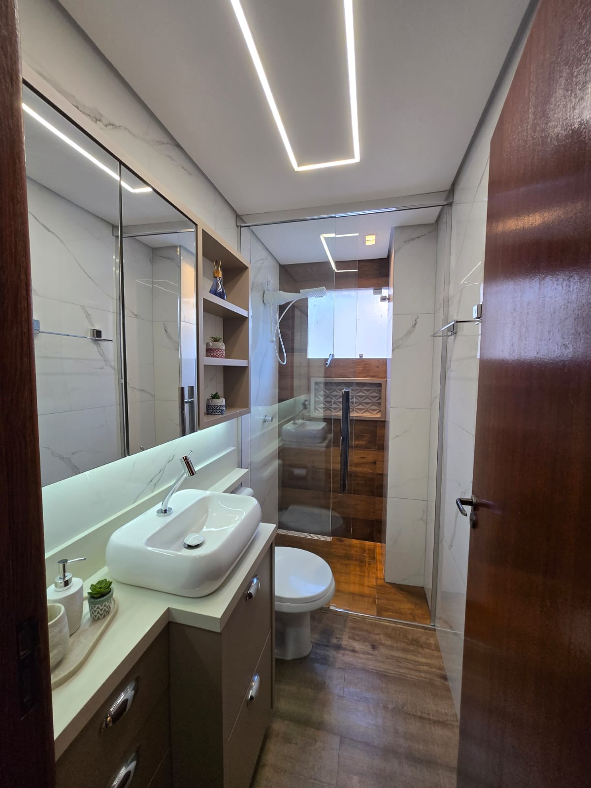 Banheiro reformado com box de vidro e porcelanato