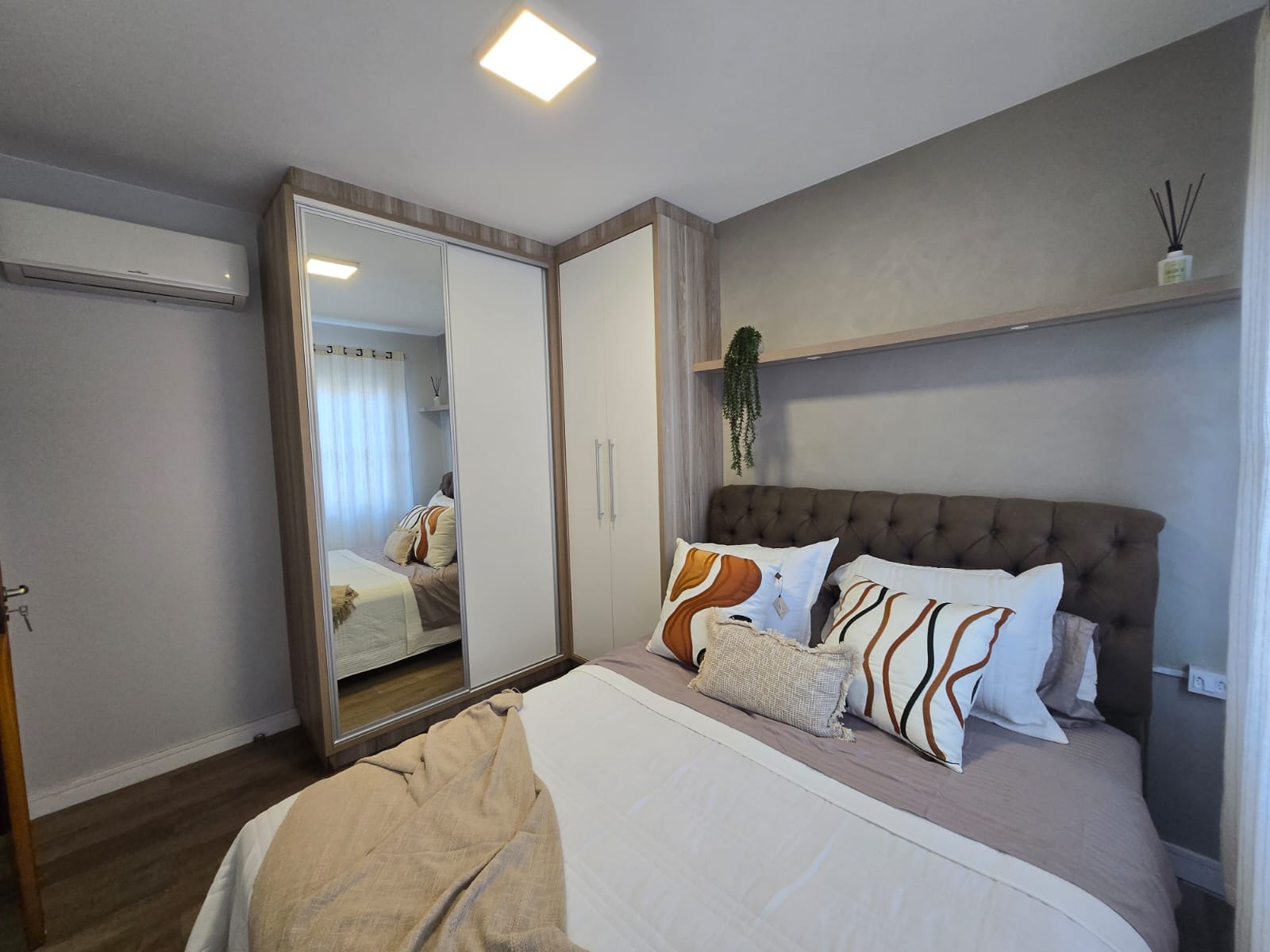 Quarto principal com guarda-roupa espelhado e ar-condicionado